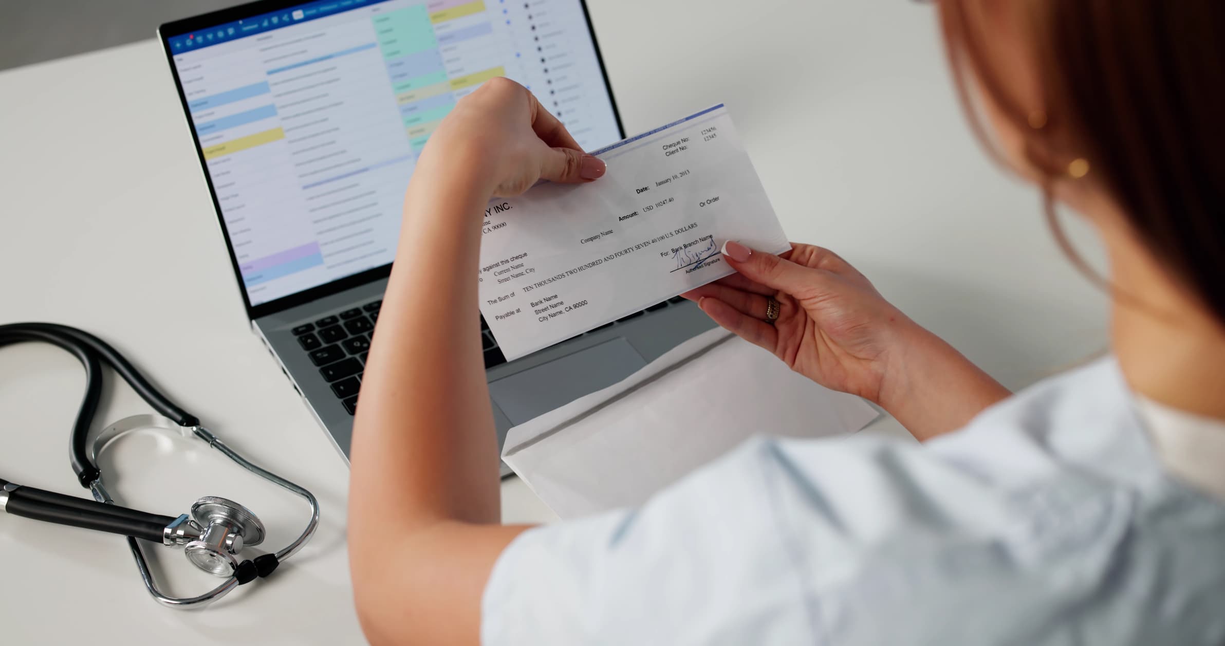 Healthcare payment check reviewed beside a laptop